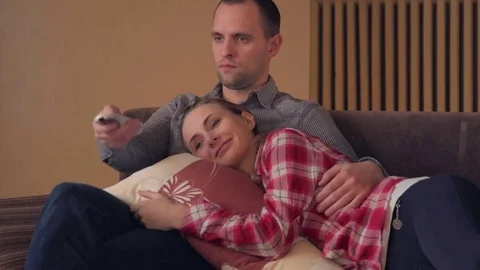 Couple watching comedy on tv on sofa 스톡 동영상 72478771