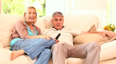 Couple watching hilarious programme on TV Stock Footage 2872150