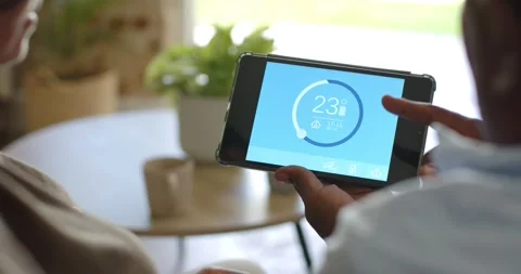 Couple watching man on right bringing finger near tablet, adjusting thermostat Stock Footage 340070636