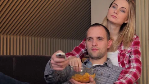 Couple watching movie on couch while eating snacks Stock-Footage 72475996