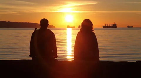 Couple watching sunset at the beach 01 Stock Footage 30248594