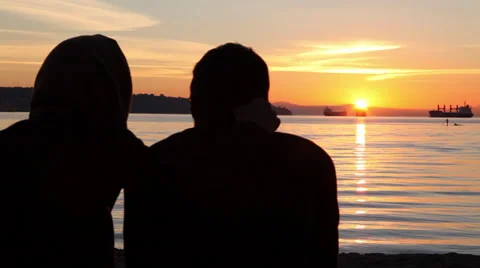 Couple watching sunset at the beach 02 Stock Footage 30248633