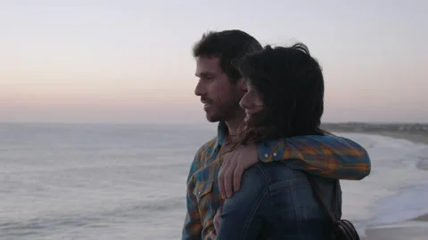 Couple watching sunset on beach Stock Footage 131156140