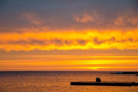 Couple watching sunset Stock Photos