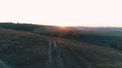 Couple watching sunset while riding bicycles Stock Footage 130156178