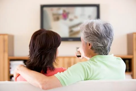Couple watching television using remote control Stock Photos