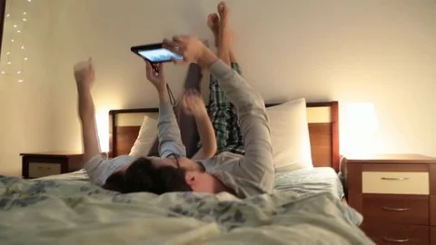 Couple watching video on the tabletl Stockbeeldmateriaal 73450197