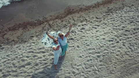 COUPLE WAVING AT BEACH TO A DRONE Stock Footage 112228770