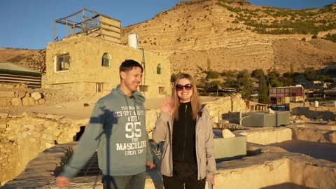 Couple waving to camera at golden hour in Dana Village, Jordan, with 库存影片 345185045