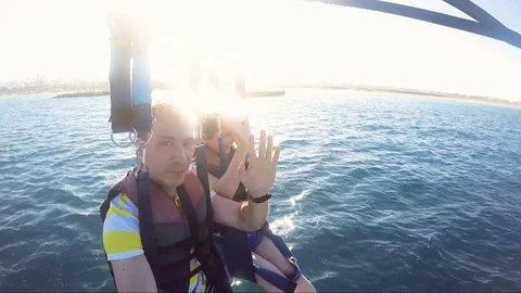 Couple Waving Hello Hands While Parasailing Stock Footage 77865605