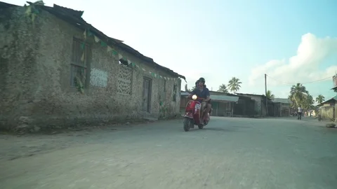 Couple waving to kid while driving scooter on road Stock Footage 85783381