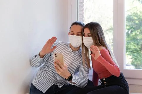 Couple wearing a face mask while videocalling their family during quarantine Stock-Fotos