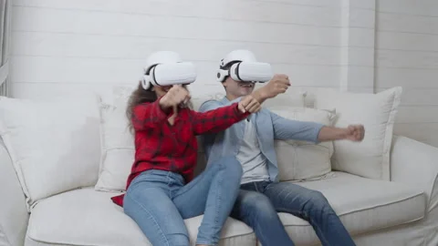 Couple wearing virtual reality headset playing a racing game Video stock 166037982