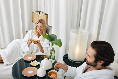 Couple while romantic weekend. Loving young couple in white bathrobes spendin Stock Photos