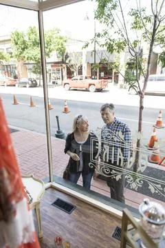 Couple window shopping at storefront Stock Photos
