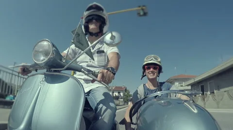 Couple of woman and man riding a vintage sidecar Vespa. Stock Footage