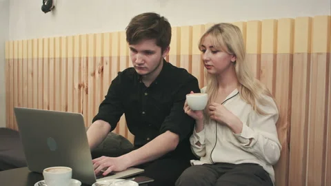 Couple working on laptop, drinking coffee at cafe Stock Footage 122146640