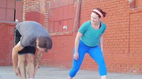 A couple working out and stretching together in an urban environment, slow motio Stock Footage 68537007