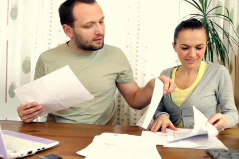 Couple working with pile of bills  Stock Footage 1007139