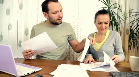 Couple working with pile of bills  Stock Footage 1007440