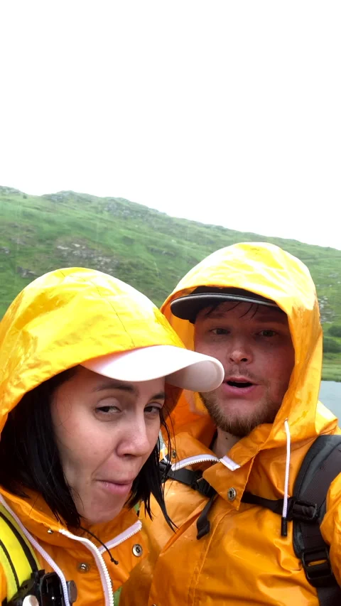 Couple in yellow taking selfie in front of Nesamovite lake at rainy weather Stock Footage 211389806