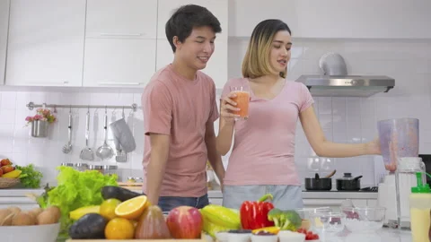 Couple young asian preparing vegetarians drinking fresh smoothie and smile enjoy Stock Footage 147372180