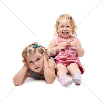 Couple of young little girl sitting over isolated white background Stock Photos