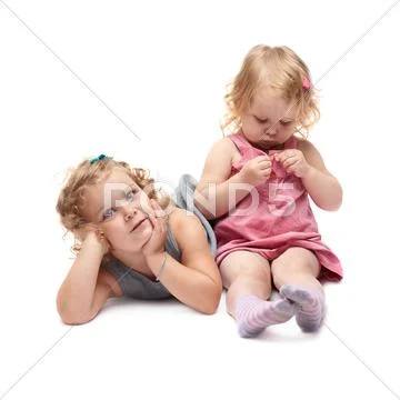 Couple of young little girl sitting over isolated white background Stock Photos
