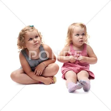 Couple of young little girl sitting over isolated white background Stock Photos