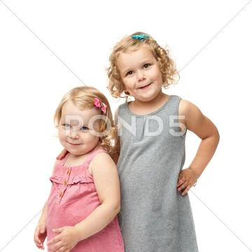 Couple of young little girls standing over isolated white background Stock Photos