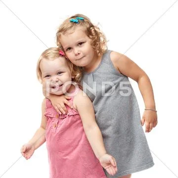 Couple of young little girls standing over isolated white background Stock Photos
