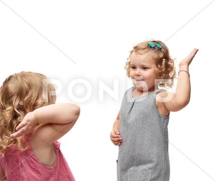 Couple of young little girls standing over isolated white background Stock Photos