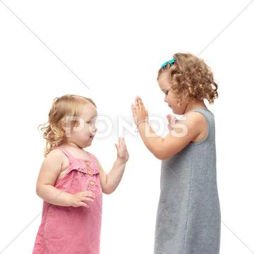 Couple of young little girls standing over isolated white background Stock Photos