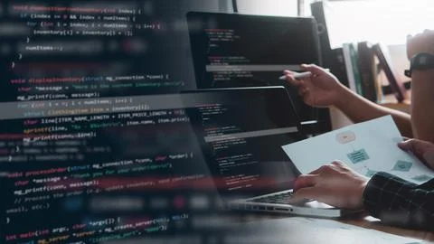 Couple Young programmer writing program code sitting at the workplace with .. 스톡 사진