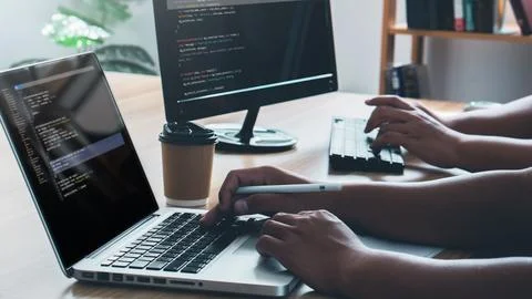 Couple Young programmer writing program code sitting at the workplace with .. Photos