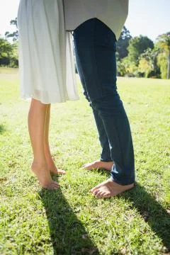 Couples bare feet standing on grass Stock Photos