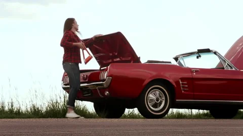 Couple's car breaks down, due to engine problems while driving a classic cherry Stock Footage 199632404