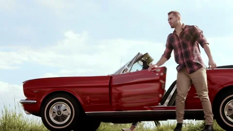 Couple's car breaks down from a mechanical fault while driving a classic cherry Stock Footage 199632357