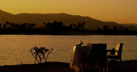 A couple's dinner table overlooking the Nile river at magic hour Stock Footage 209950472