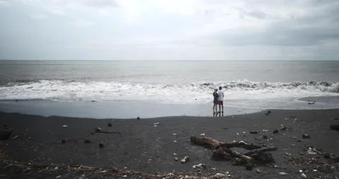 Couples on Dirty Black Sand Beach in Bali Stock Footage 238459097