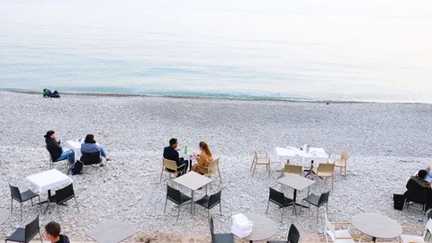Couples eat in a restaurant by the sea in winter in nice on the cote d'azur Stock Footage