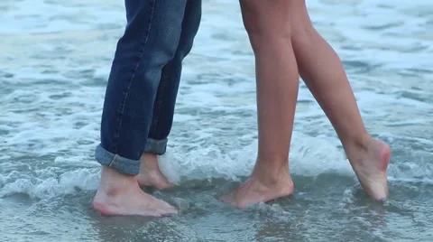 Couple's Feet Playing In Ocean Waves Kissing Video stock 53232586