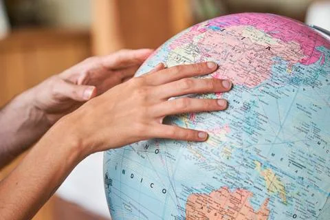 Couple's hands exploring world globe Stock Photos
