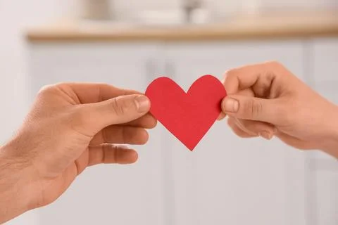 Couples hands holding a red paper heart, love, care, and relationship Concept Stock Photos