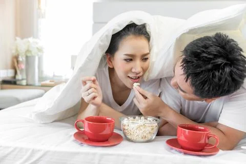 Couples having breakfast on bed Stock Photos