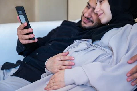 Couples having online call, checking internet about pregnancy in their livi.. Stock Photos