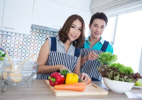Couples in kitchen Stock Photos