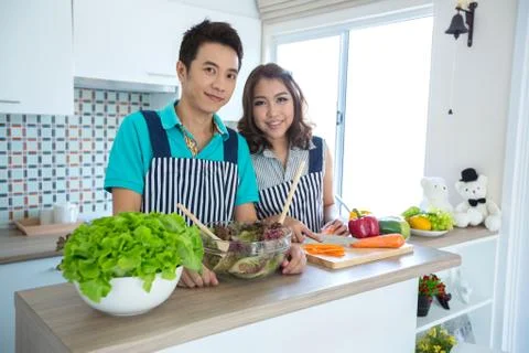 Couples in kitchen Stock Photos