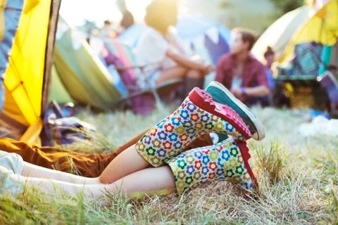 Couple's legs sticking out of tent at music festival Stock Photos