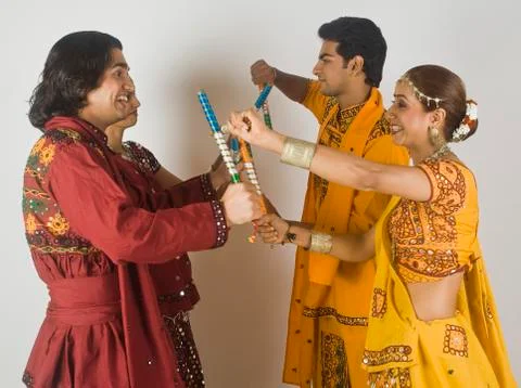Couples performing dandiya Stock Photos